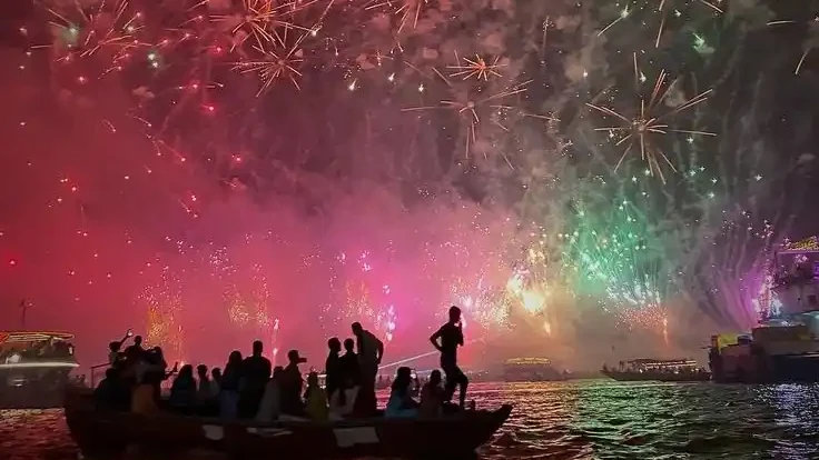 Dev Deepawali fireworks over the Ganga with boats full of travelers in Varanasi